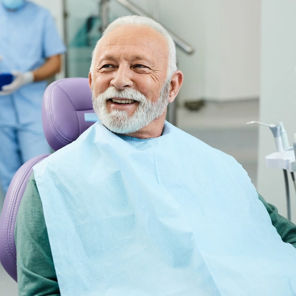 Older adult smiling after an All-on-4 dental implant consultation