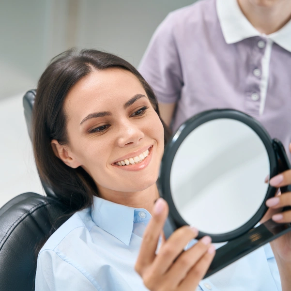 Patient checking her smile before a CEREC same-day dental crown procedure