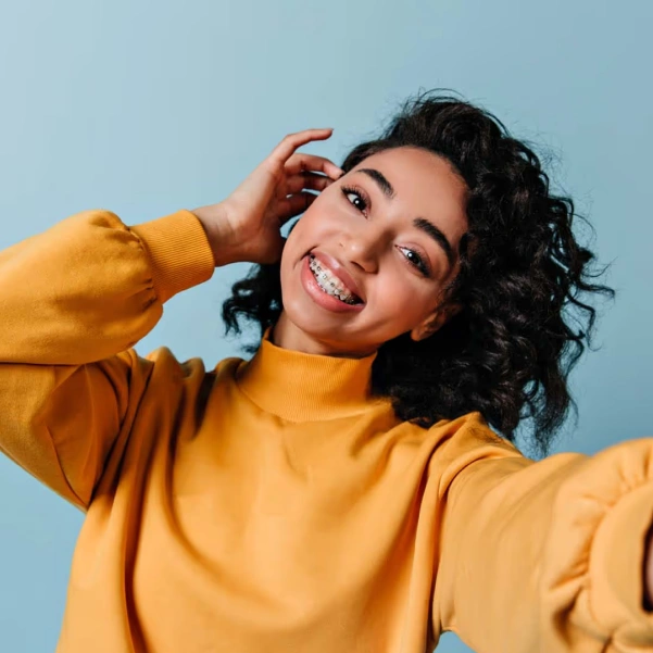 Smiling woman showing results of cosmetic braces treatment