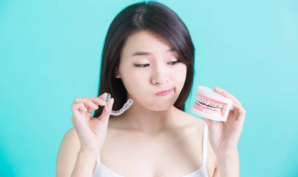Woman holding clear aligners before orthodontic treatment