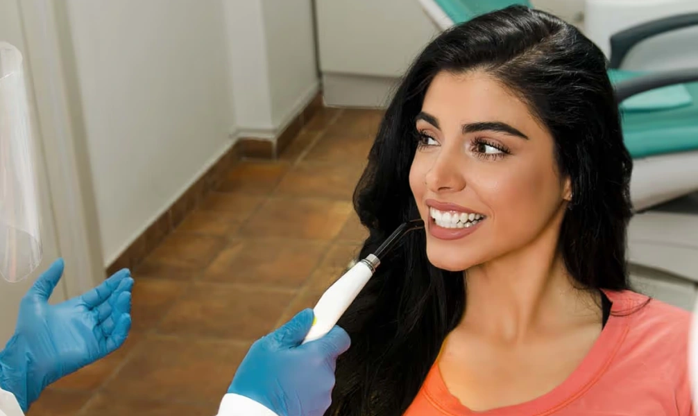 Dentist performing cosmetic dental bonding on a patient
