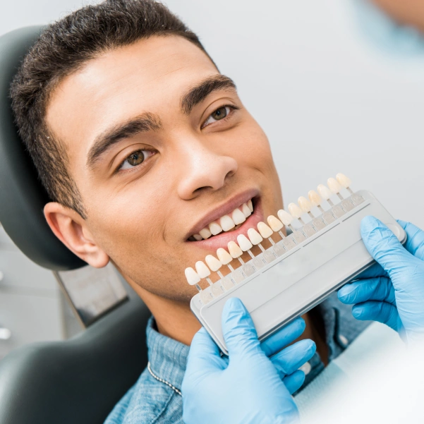 Patient holding porcelain laminates before smile enhancement