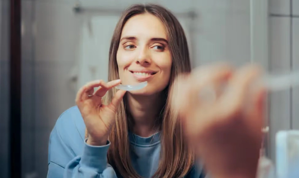 Woman holding a clear night guard used for bruxism treatment