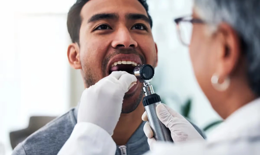 Dentist performing an oral cancer screening examination