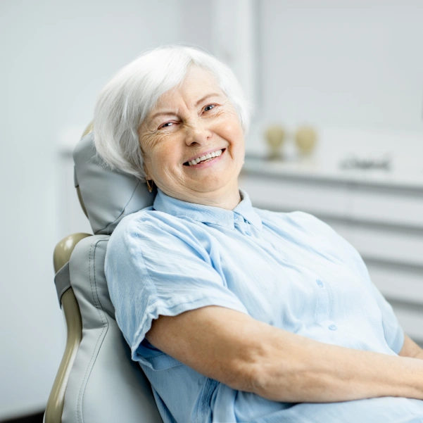 An older woman smiling during an implant-supported denture appointment