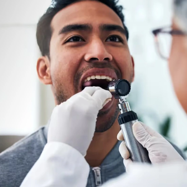 Dentist performing an oral cancer screening examination