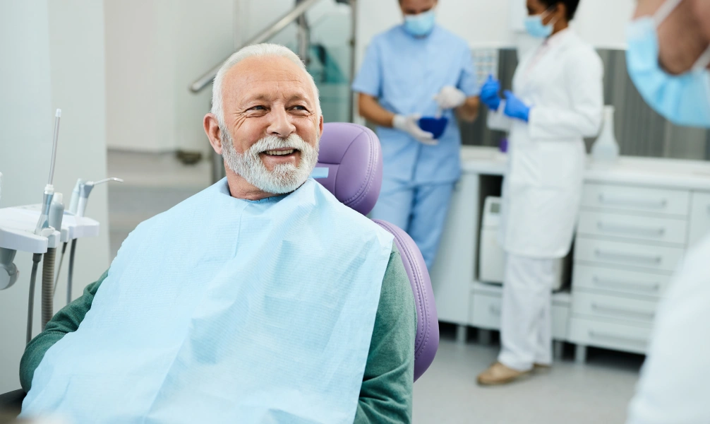 Older adult smiling after an All-on-4 dental implant consultation