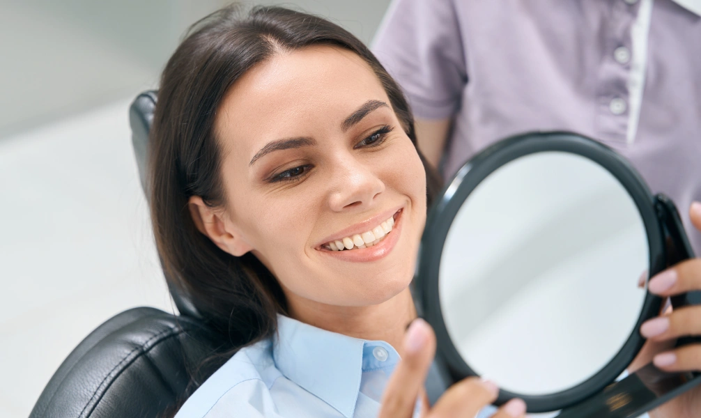 Patient checking her smile before a CEREC same-day dental crown procedure