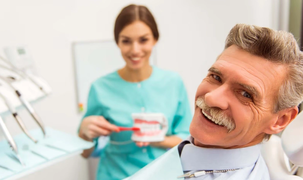 Patient holding a removable denture during a restorative dentistry visit