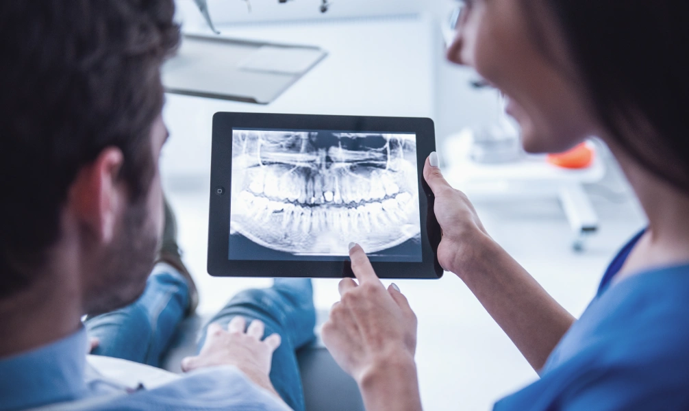 Dentist reviewing dental X-rays before an oral surgery procedure