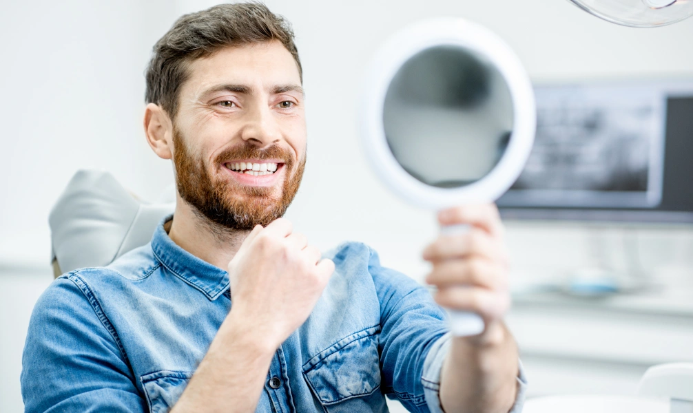 Patient examining his smile during a ridge augmentation consultation
