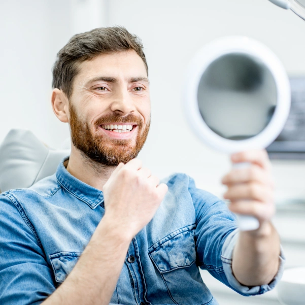 Patient examining his smile during a ridge augmentation consultation